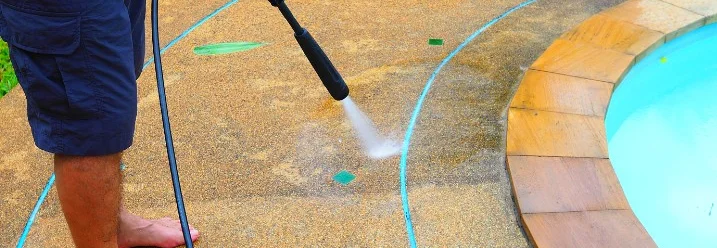 Person reinigt Poolrand mit Hochdruckreiniger